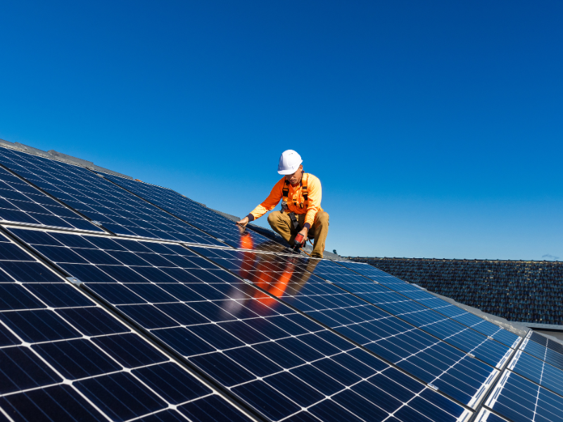 Solar installer on a roof with solar panels